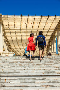 Rear view of people walking on staircase