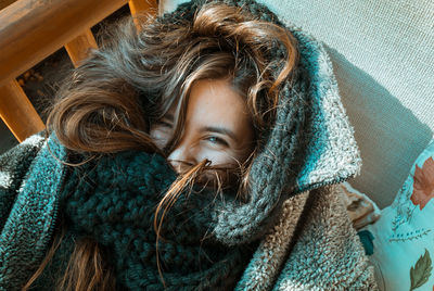 Portrait of smiling young woman face covered with scarf