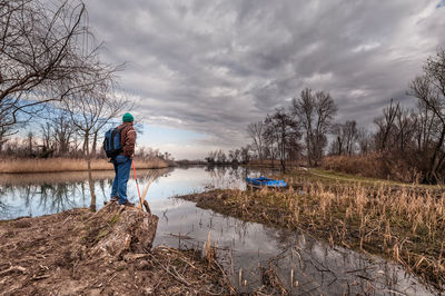 Man standing in lake against sky