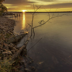 Scenic view of lake against sky at sunset