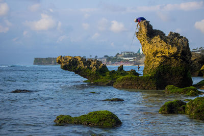 Rock formation on sea against sky