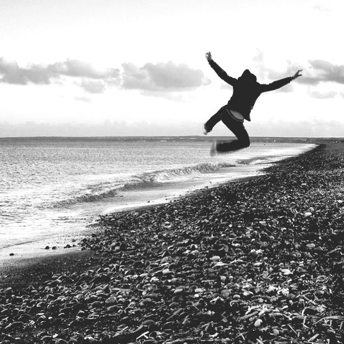 sea, horizon over water, sky, lifestyles, leisure activity, full length, beach, water, shore, cloud - sky, standing, tranquil scene, jumping, vacations, scenics, carefree, beauty in nature, tranquility