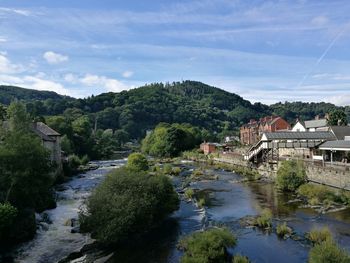 Scenic view of river by town against sky