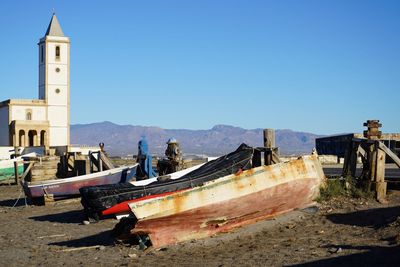 Abandoned ship on beach against clear blue sky