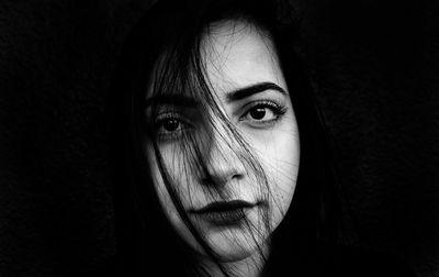 Close-up portrait of woman on black background