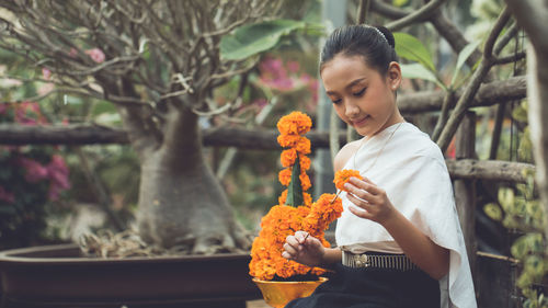 Happy boy holding cross on plant