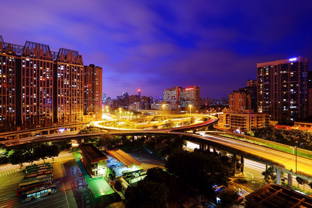 illuminated, night, city, architecture, building exterior, built structure, light trail, cityscape, high angle view, sky, transportation, long exposure, city life, traffic, street light, bridge - man made structure, connection, street, motion, road