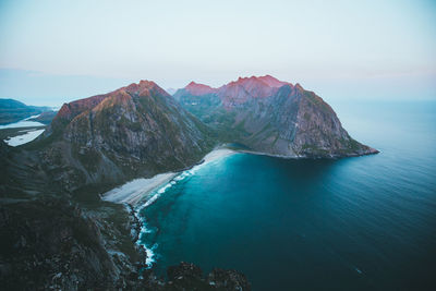 Scenic view of sea and mountains against clear sky