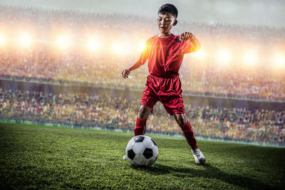 Woman playing soccer ball on field