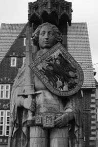 Low angle view of statue against building in city