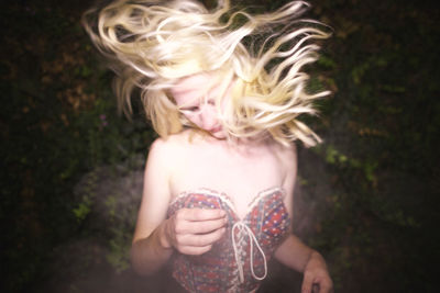 Close-up of sensuous woman dancing against plants