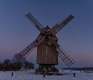 Traditional windmill against clear sky during winter