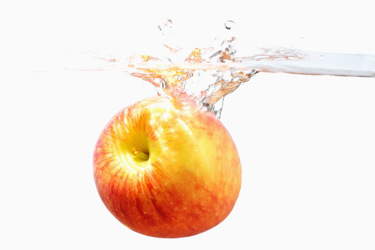 CLOSE-UP OF APPLE AGAINST GRAY BACKGROUND