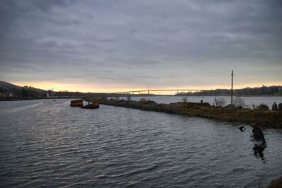 Scenic view of river against sky at sunset