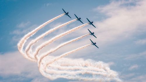 Low angle view of airshow against sky