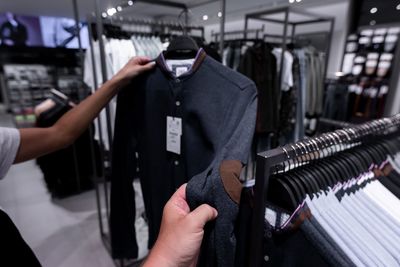 Midsection of men holding jacket on store