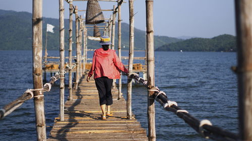 Rear view of man walking on pier