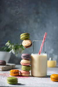 Flying levitating colourful macaroon cookies with milk spring mood light colours front view