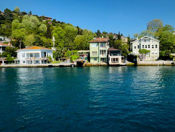 Building by sea against clear blue sky