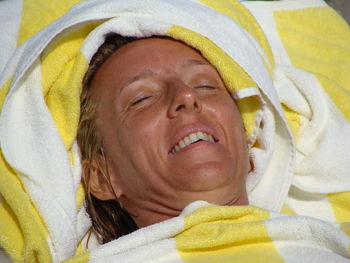 Close-up of smiling mature woman sunbathing