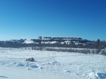 Scenic view of frozen landscape against clear blue sky