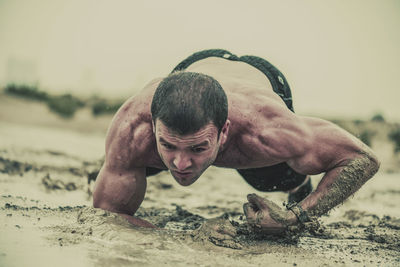 Full length of shirtless man lying on land