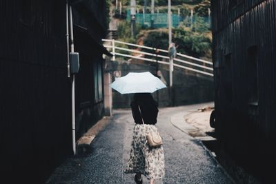 Rear view of woman walking in rain