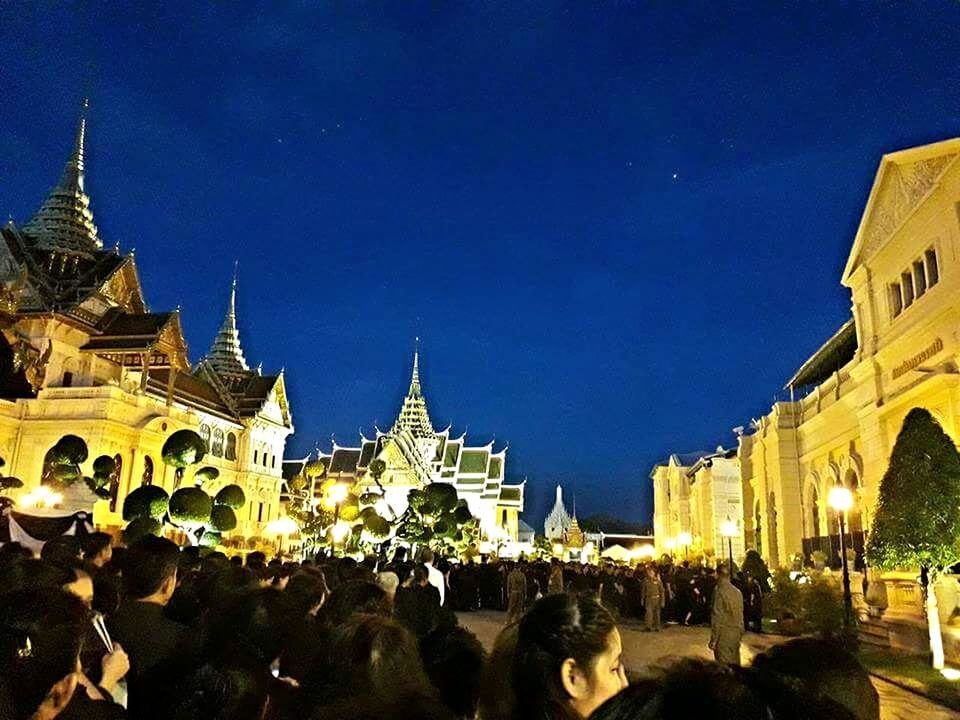 PEOPLE AT ILLUMINATED TEMPLE AGAINST SKY