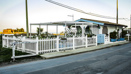 Road by buildings against sky