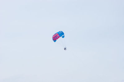 Low angle view of person paragliding against clear sky