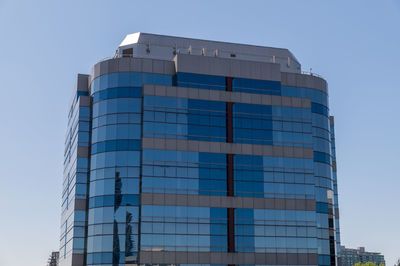 Low angle view of modern building against clear blue sky