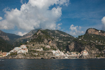 Scenic view of sea by buildings against sky