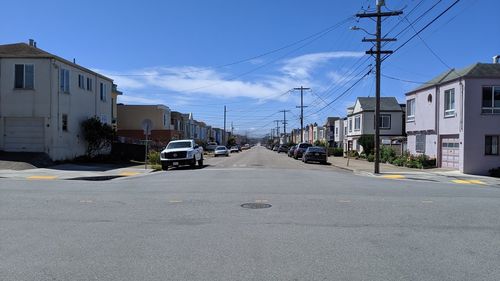 Road amidst buildings in city against sky