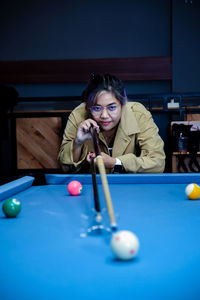 Portrait of woman playing pool