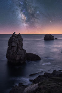 Scenic view of rocks in sea against sky