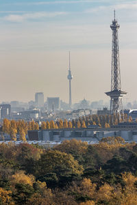 Communications tower in city against sky