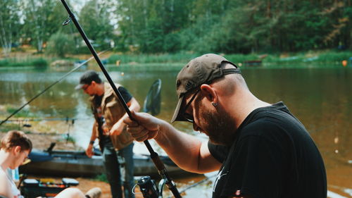 Rear view of men fishing in lake