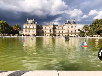 View of buildings in lake against cloudy sky