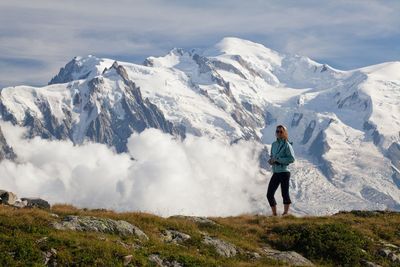 Man standing on snowcapped mountain against sky