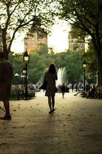 Rear view of people walking on road