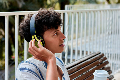 Portrait of a young man with afro hair is listening to music in