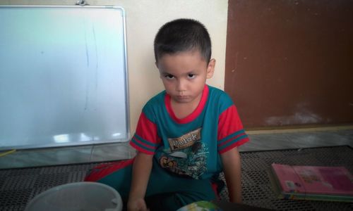 Boy sitting on sofa at home