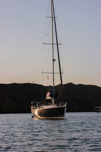 Sailboat sailing on sea against clear sky