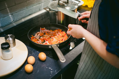 Midsection of woman preparing food in kitchen