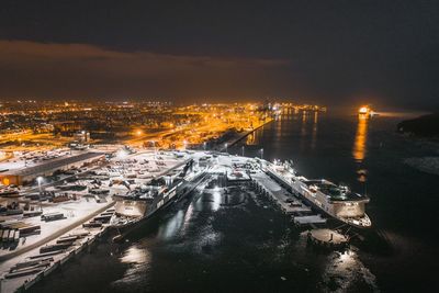 Aerial view of illuminated city against sky at night