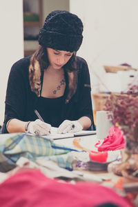 Young woman writing in diary at table