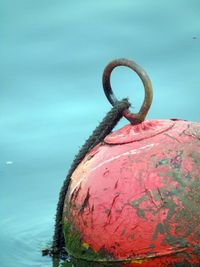 Close-up of damaged red buoy in lake