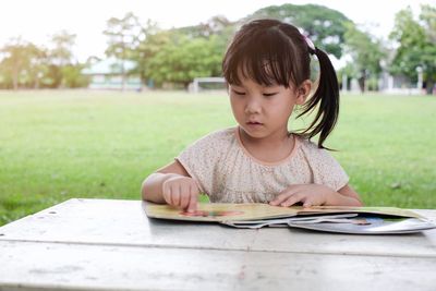 Portrait of cute girl holding paper outdoors