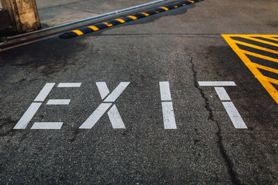 Exit sign stenciled on concrete ground with white paint