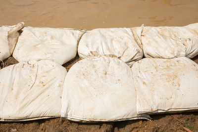 Close up shot of sandbags stacked in row as barrier to protect catastrophe, such as flooding 